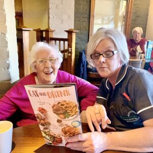 Care worker reading a menu to client